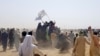 People on vehicles gather near Friendship Gate crossing on Pakistan-Afghanistan border, in Chaman